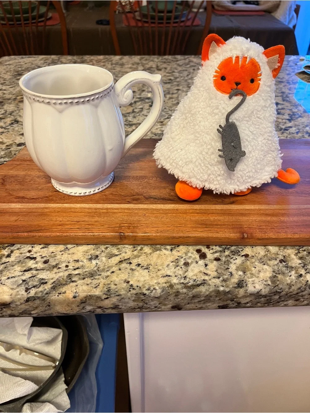Plush soft small Cat disguised as a ghost costume showing off its mouse catch